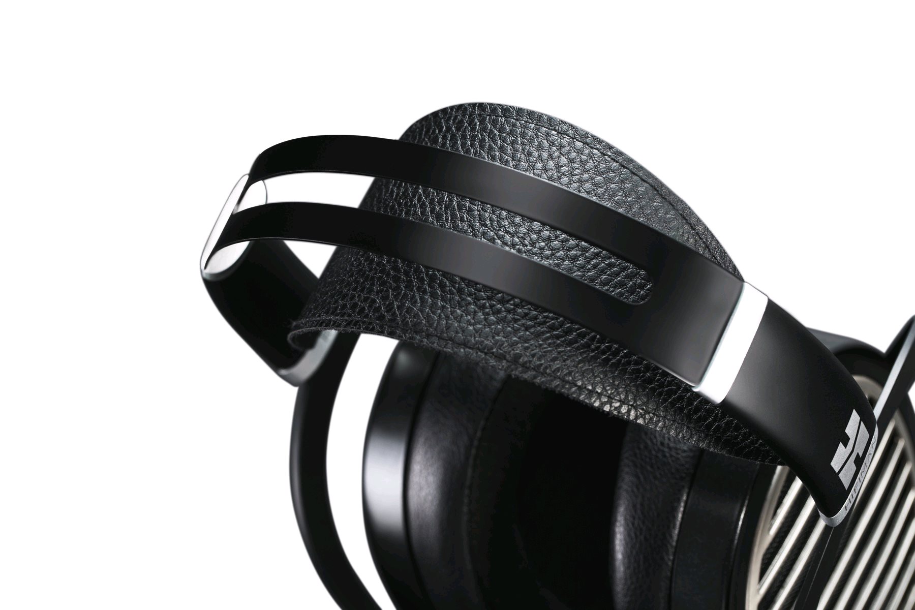 Detail hlavového mostu HIFIMAN Ananda — pružný pásek s odděleným koženým popruhem a kovovým spojem