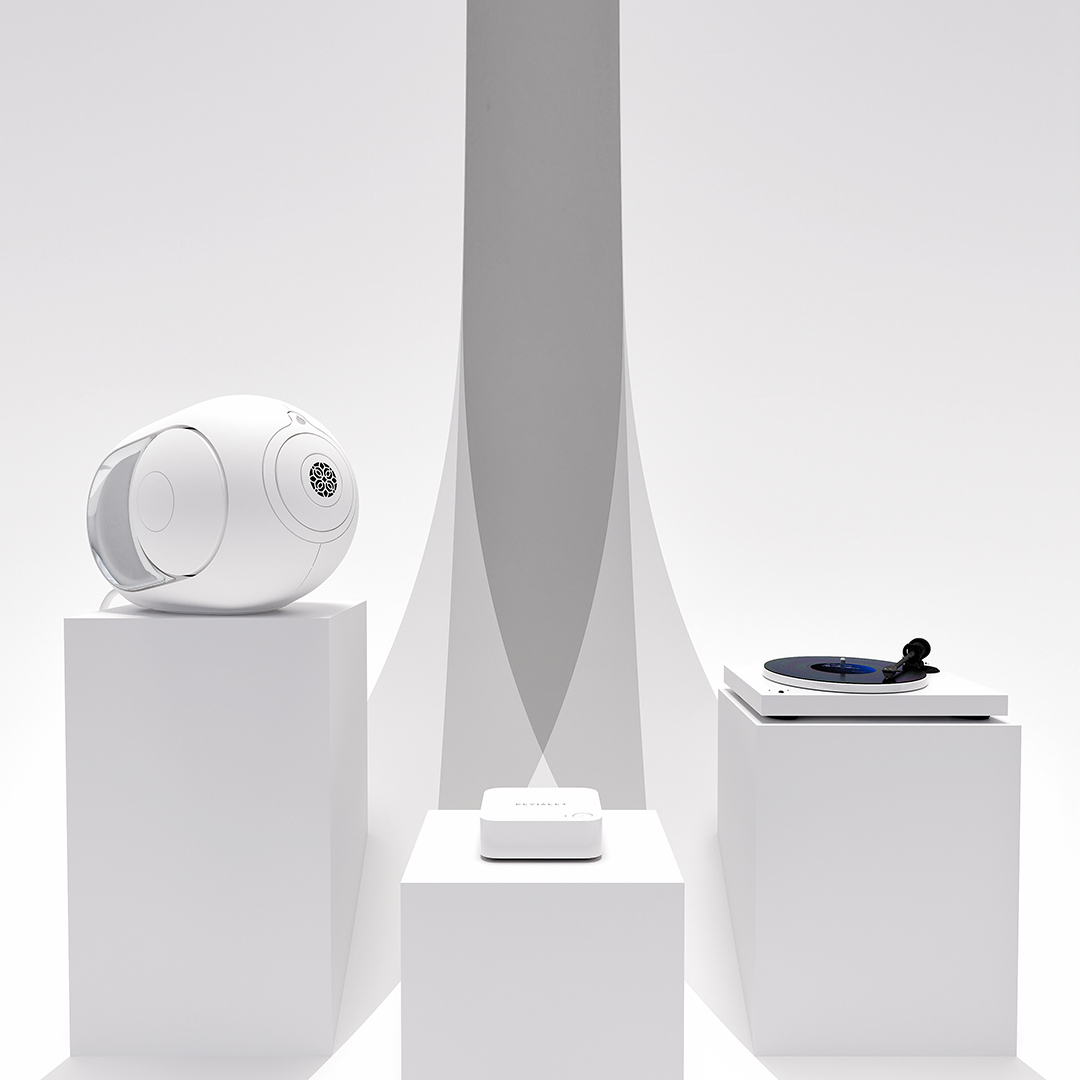 Devialet ARCH v obývacím pokoji vedle gramofonu a reproduktoru Devialet Phantom