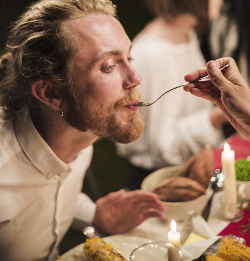 hand-with-spoon-feeding-man-dinner