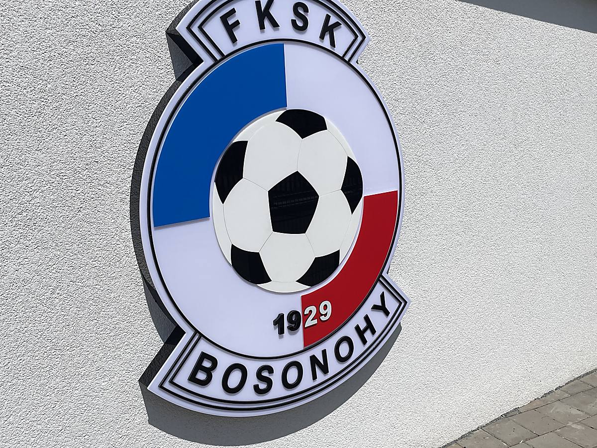 Klubový znak FKSK Bosonohy na bílé fasádě za dne