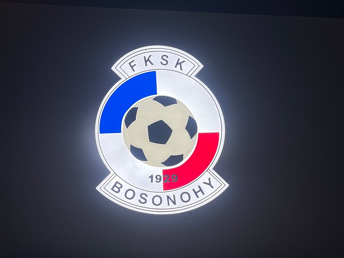 Podsvícený klubový znak FKSK Bosonohy na fasádě po setmění