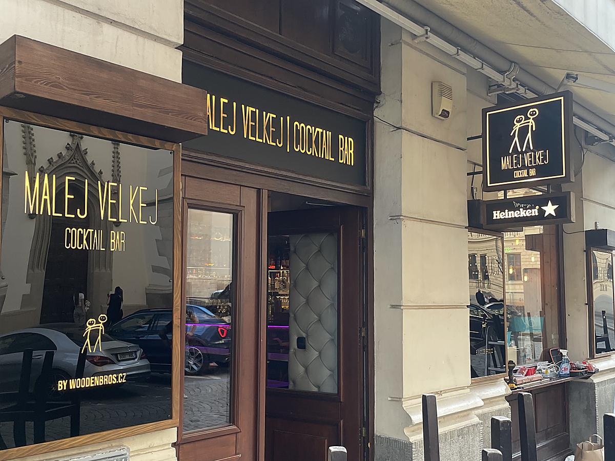 Zlatý nápis a logo na výloze baru