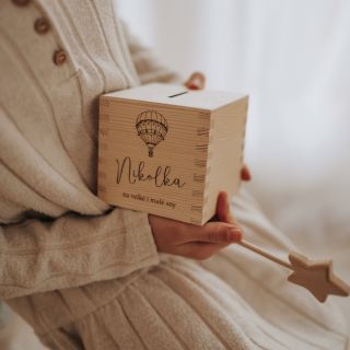 Dřevěná pokladnička se jménem, která schovává první mince, tajná přání i malé sny. Každý cinknutý penízek vypráví svůj...