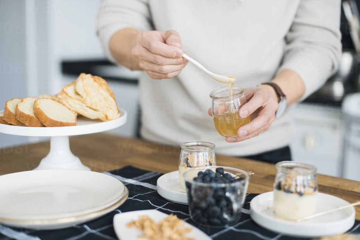 midsection-of-man-preparing-breakfast-at-table-in-kitchen-CAVF29792