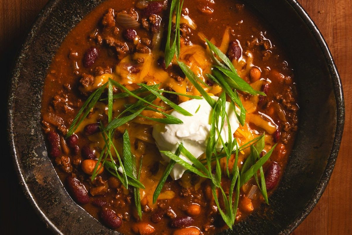 Chilli con carne s fazuľou, kyslou smotanou a jarnou cibuľkou