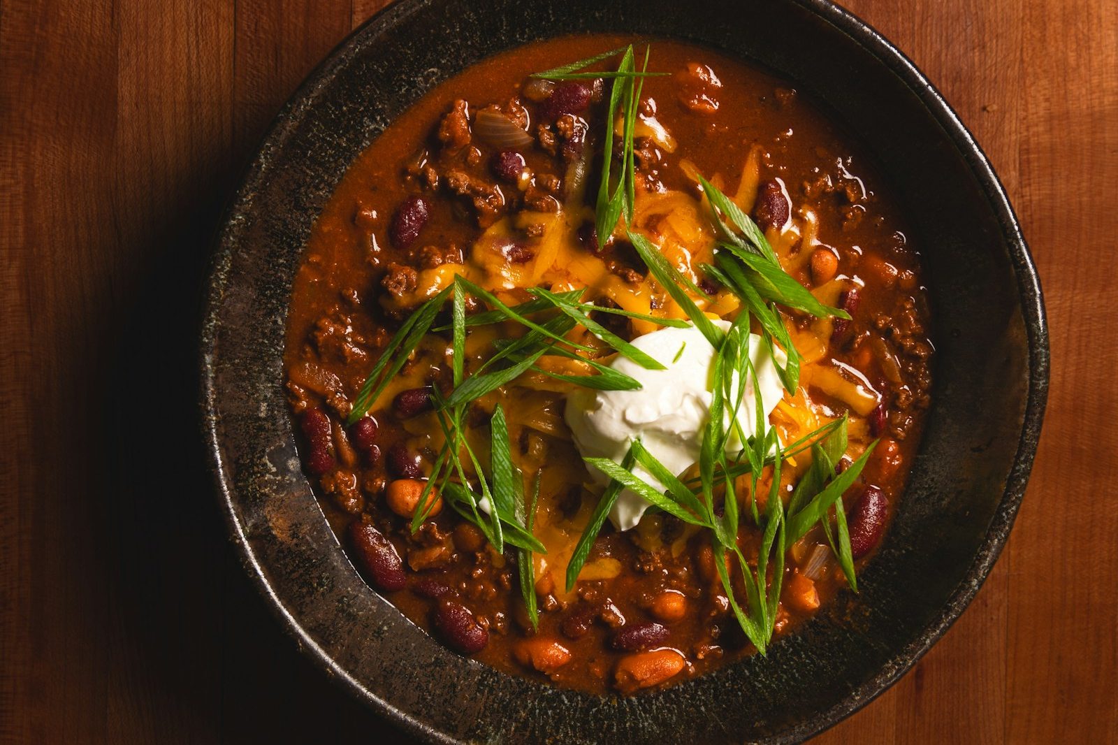Chilli con carne s fazuľou, kyslou smotanou a jarnou cibuľkou