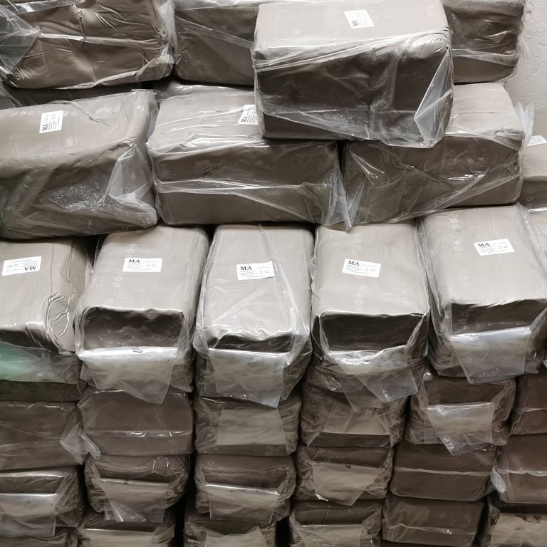 Sklad s naskládanými balíky keramické hlíny MA