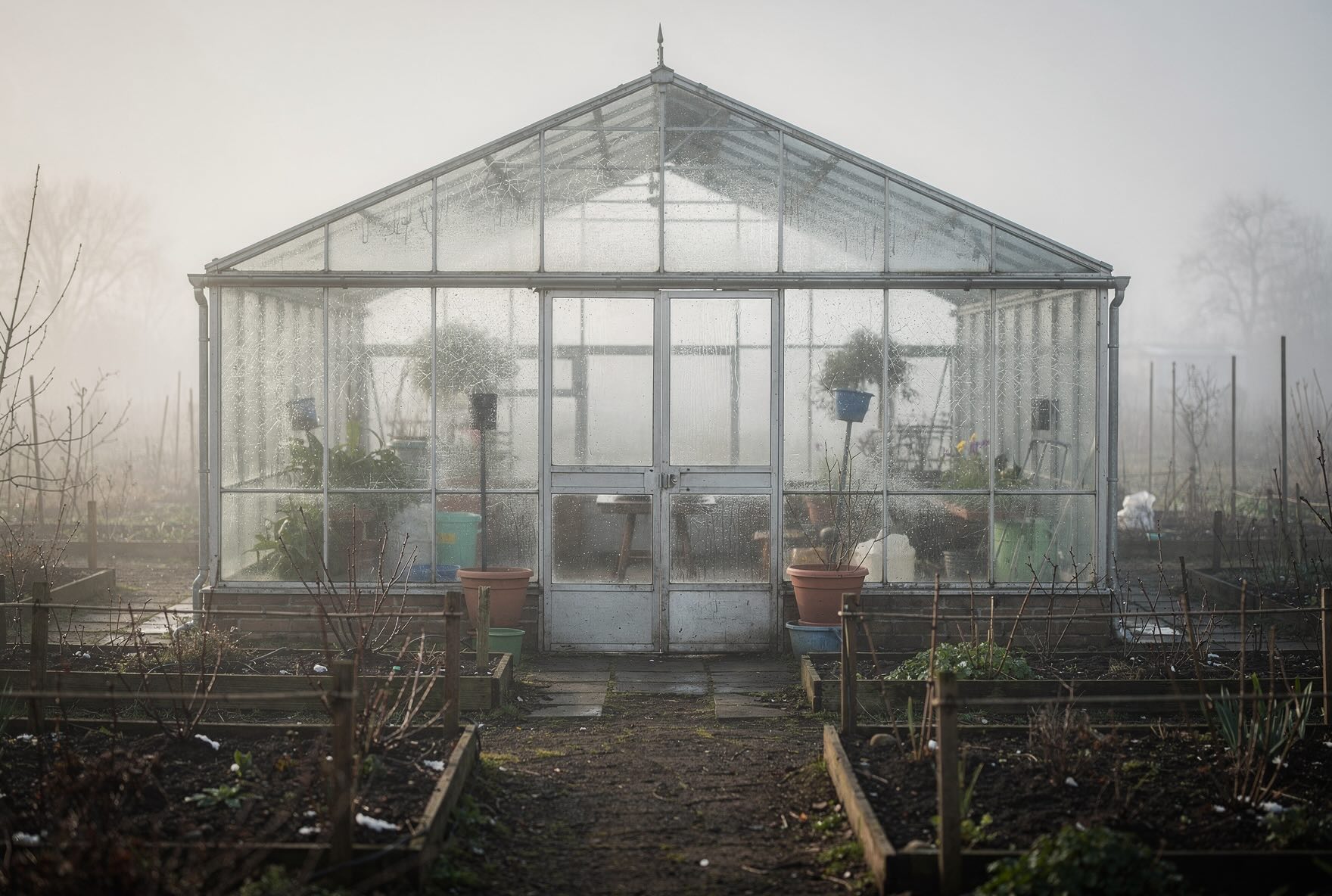 sklenik-po-zime-zamlzena-skla-a-hola-zahrada-kolem
