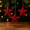 trpytive-cervene-vanocni-hvezdy-zavesene-na-strome-s-vanocnimi-svetylky