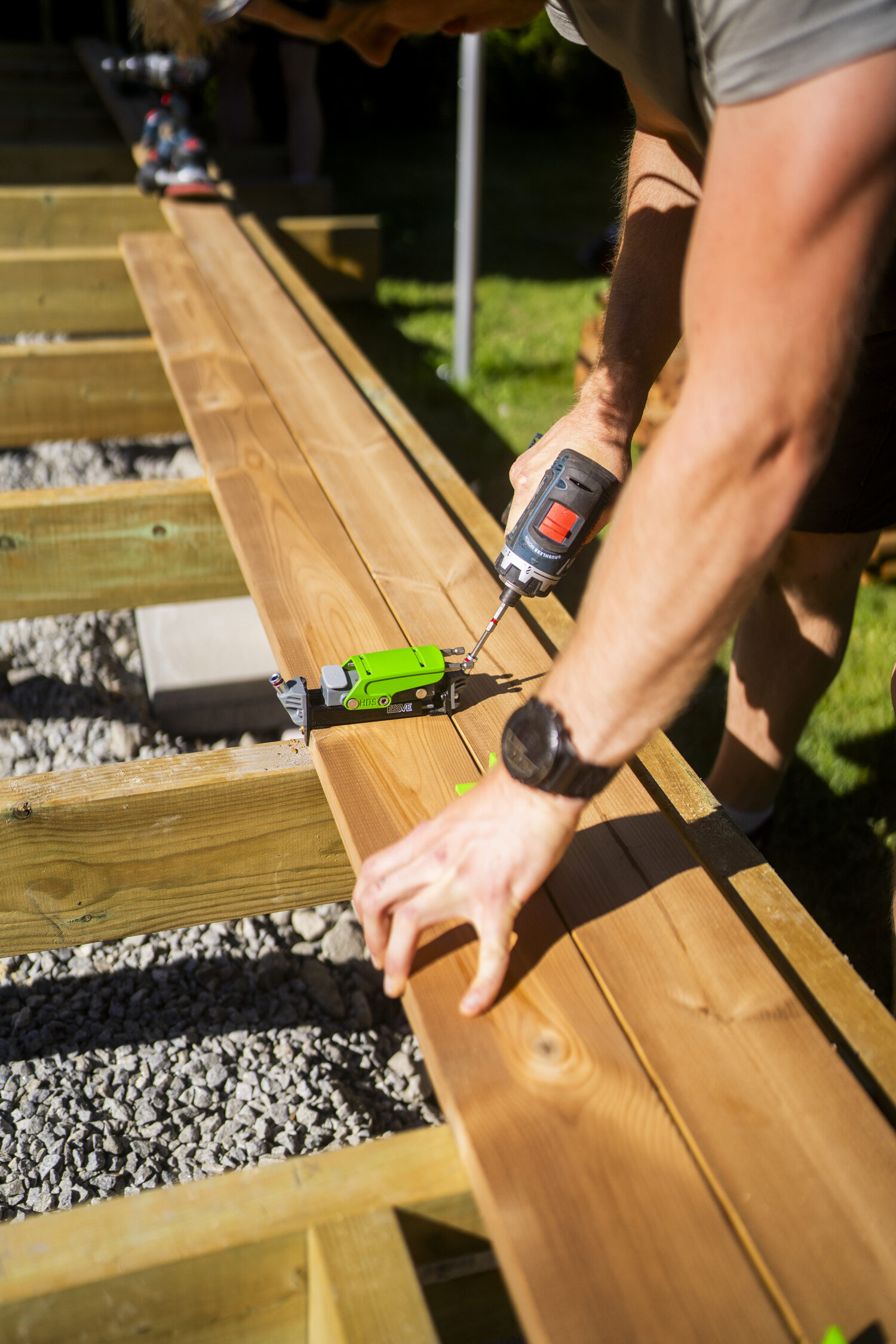 Stolár na terase zapúšťa skrytú terasovú skrutku pomocou nástroja Hidden Decking.